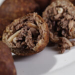Close-up of plant-based Kibbeh cut open to reveal vegan minced meat and pine nut filling – Amoria Foods
