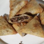 Amoria plant-based beef samosas cut in half, showing vegan minced beef filling with onions and herbs