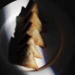 Golden plant-based beef samosas arranged in a line on a white plate – Amoria Foods vegan mince filling